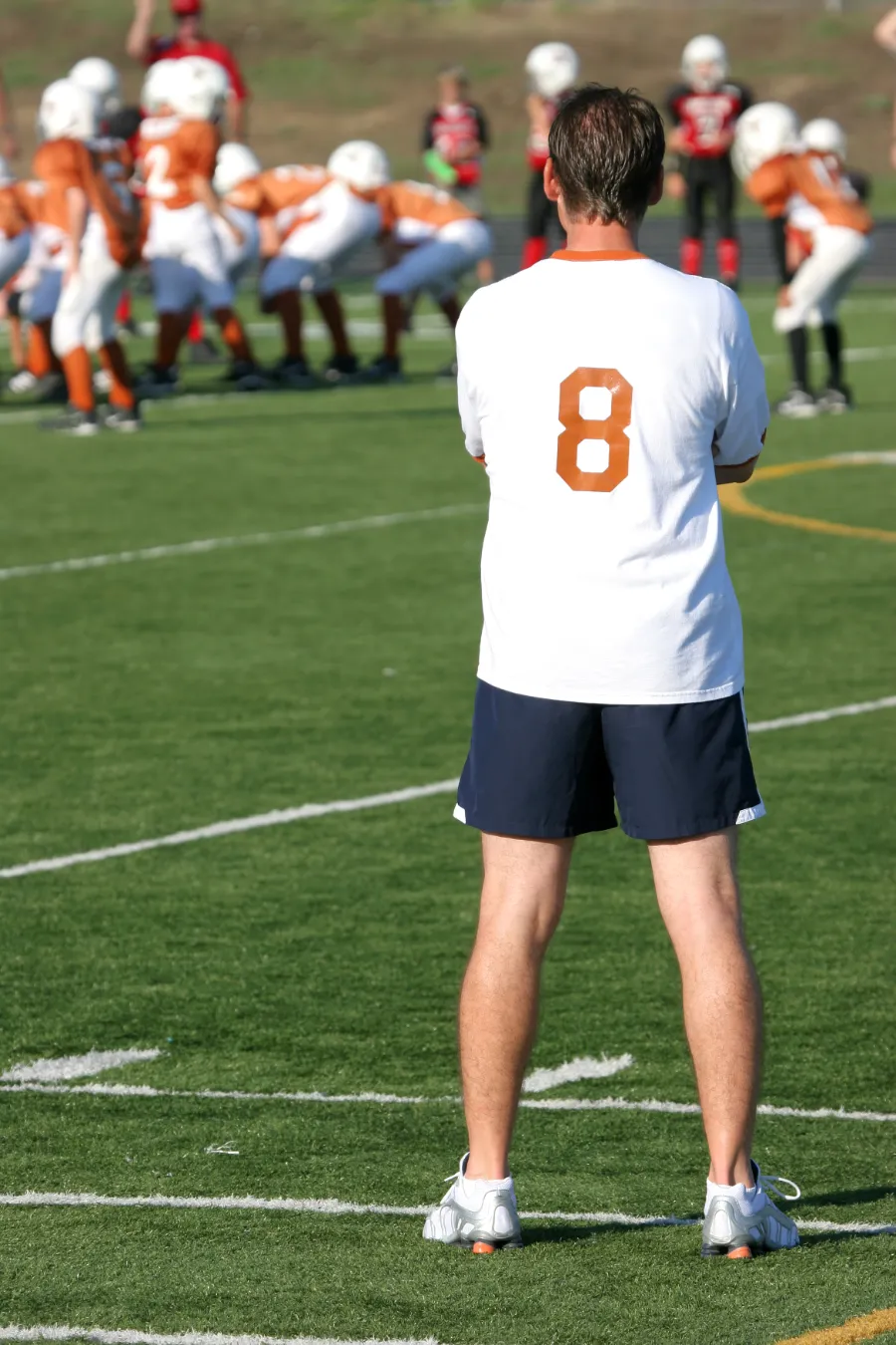 coach observing football team